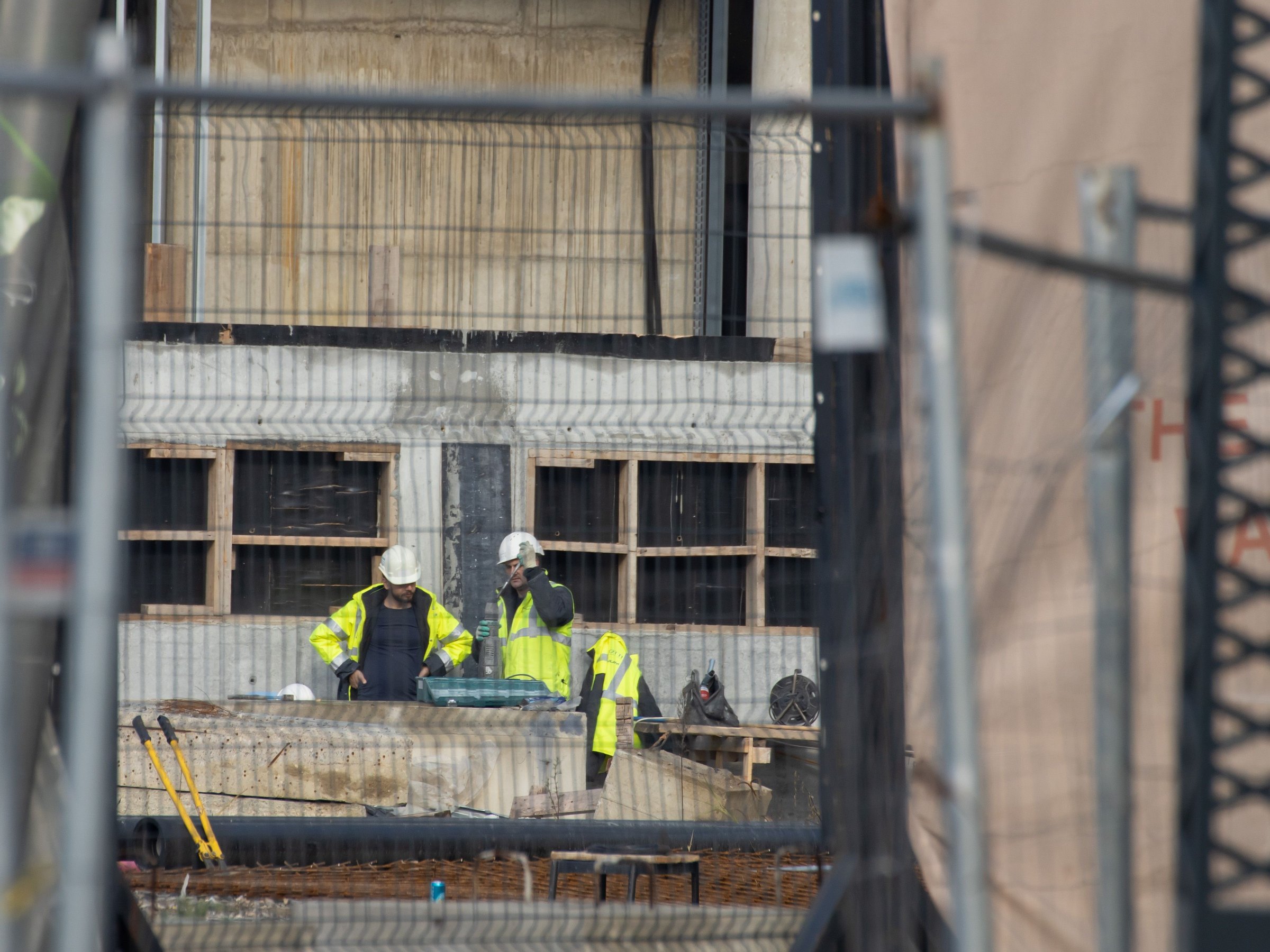 Construction personnel in protective helmets and high-visibility workwear on site
