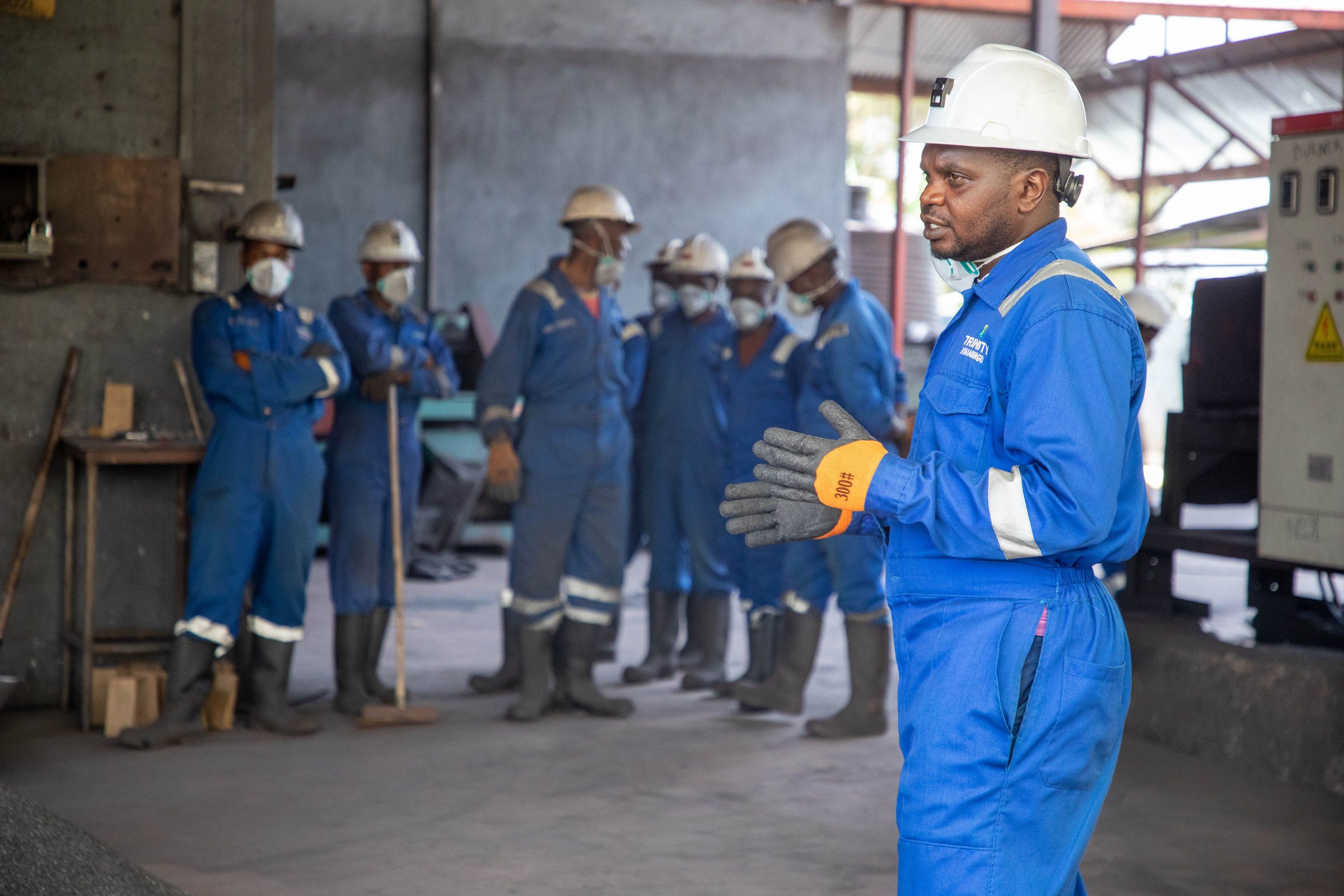 Factory workers in protective equipment attending a practical training session